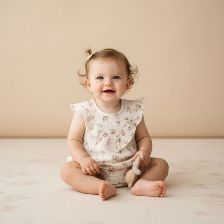 Organic Cotton Sleeveless Ruffle Bubble Romper - Blush Floral, close-up of ruffle trim and snap closures showing soft organic cotton interlock fabric