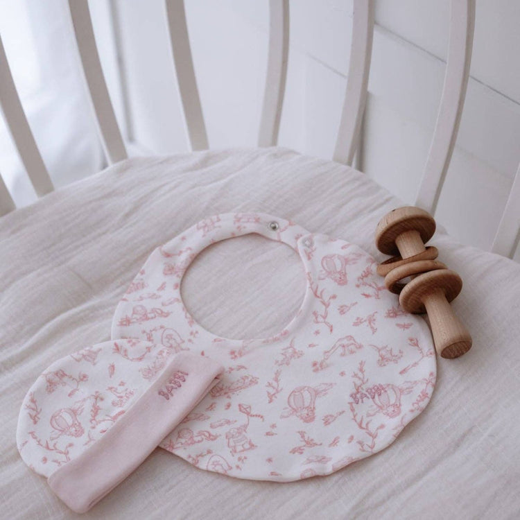 
                    
                      Toile de Jouy Bib & Hat Set in Pink - newborn bib and hat set in pink Toile de Jouy print by Atelier Babbi, 100% cotton
                    
                  