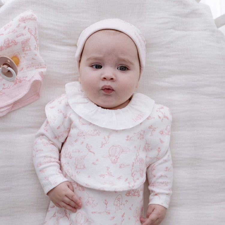 
                    
                      Toile de Jouy Bib & Hat Set in Pink - baby girl bib with Toile de Jouy pink print laid flat, Atelier Babbi newborn set
                    
                  