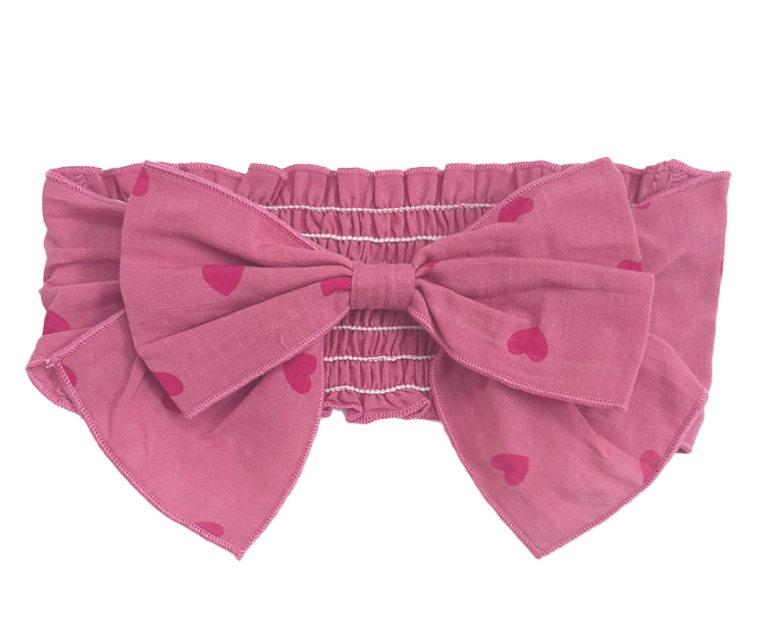 Flat lay of pink romper & headband set with bow — newborn photo outfit and baby shower gift
