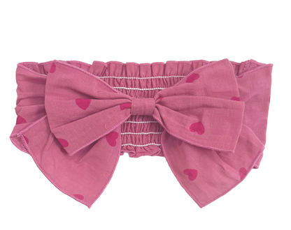 Flat lay of pink romper & headband set with bow — newborn photo outfit and baby shower gift