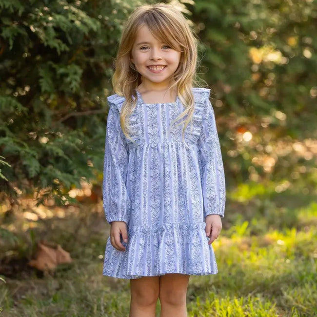 Girl wearing Georgina Striped Ruffle Dress in blue by Mabel + Honey, showing tiered gathered skirt and floral details