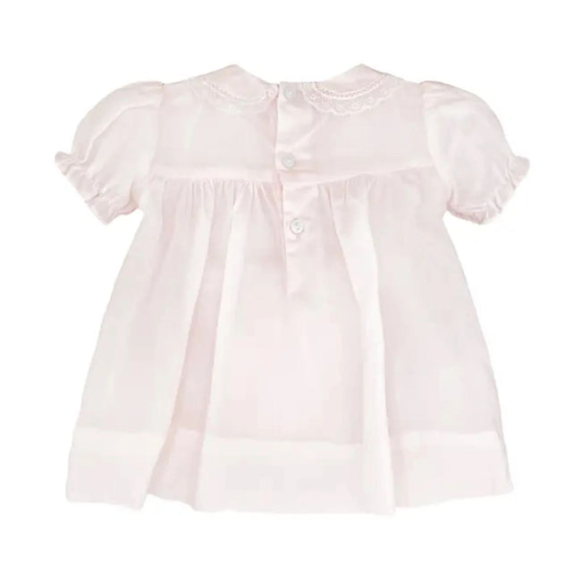 Hand-smocked white cotton baby girl dress set featuring delicate French lace trim and a matching lace-edged bonnet